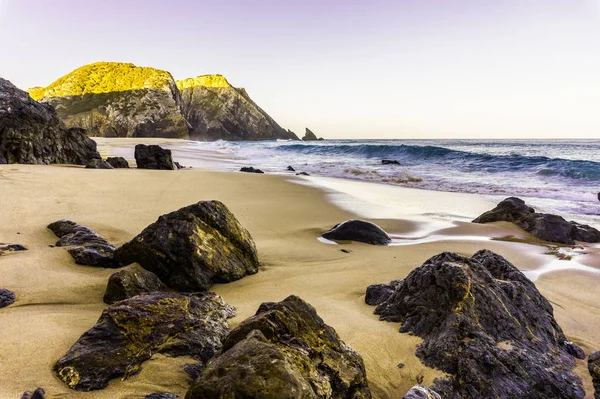 Sziklás és homokos tengerpart napkelte, Portugália. — Stock Fotó