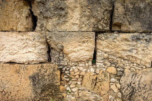 Masonry wall of old stone blocks of limestone. texture