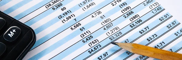 Financial income statement with calculator and pencil