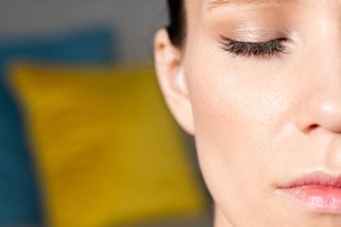 Evde meditasyon yapan çekici, rahat genç bir kadının portresini yakından çek. Gözleri kapalı bir kız.