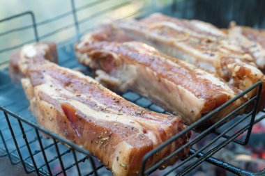 Kızarmış pirzola, baharat ve otlarla birlikte, yanan kömürlerde, bbq ızgarasında, alevler ve dumanla birlikte. Izgara çizgili et piknik kutlaması için hazır.