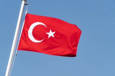 Türkiye 'nin ulusal bayrağı mavi gökyüzüne karşı rüzgarda dalgalanıyor. Türk halkının sembolü