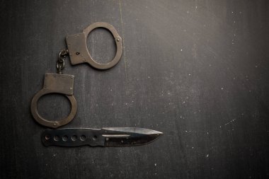 Taktik dişli bıçak ve kelepçelerin koyu arka plan üzerinde kümesi. Polis ya da askeri teçhizat kavramı.