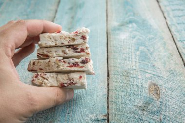 Beyaz Nuga tatlı tatlı şeker parçaları tutan el