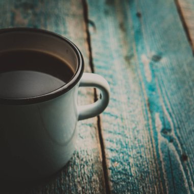 Beyaz demir kupa kahve ya da siyah çay eski mavi ahşap masa