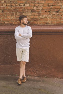 Yakışıklı genç adam tuğla duvara yakın poz şort