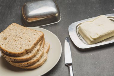 Tost ve bıçak ve karanlık tablo üzerine tereyağı ile plaka