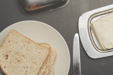 Tost ve bıçak ve karanlık tablo üzerine tereyağı ile plaka