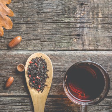 Sonbahar kompozisyon. Bir fincan çay, sonbahar yaprakları ve meşe palamudu. eski ahşap tablo.