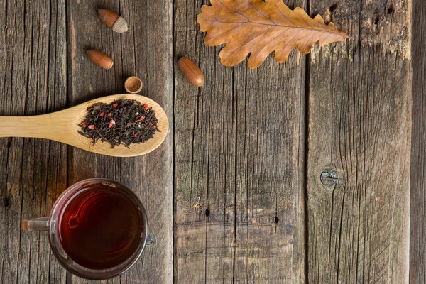 Sonbahar kompozisyon. Bir fincan çay, sonbahar yaprakları ve meşe palamudu. eski ahşap tablo.