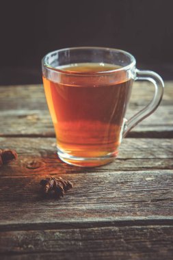 Siyah çay ahşap bir masa üzerinde bir cam bardak.