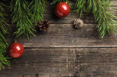 herdem yeşil çam çırpı parlak kırmızı baubles ve çam kozalakları eski ahşap zemin üzerine