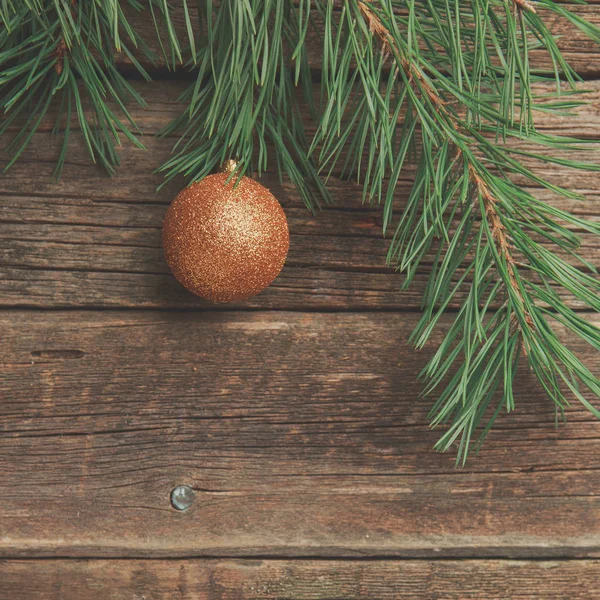 Goldene Weihnachtskugel Mit Kiefern Oder Tannenzweig Auf Alter Abgenutzter Holzoberfläche — Stockfoto