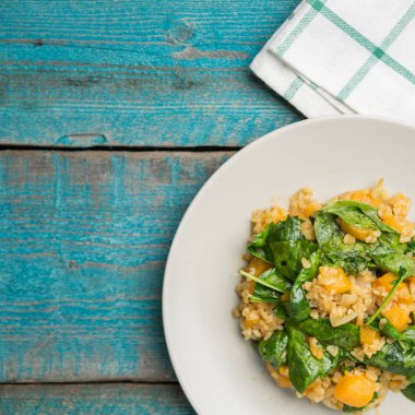 Bulgur ve ıspanaklı eski mavi zemin üzerine kabak ile plaka