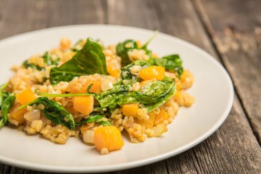 Bulgur ve ıspanaklı eski antika arka plan üzerinde kabak ile plaka