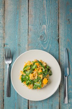 Bulgur ve ıspanaklı eski mavi zemin üzerine kabak ile plaka
