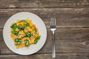 Bulgur sebze: balkabağı, soğan ve ahşap arka plan - sağlıklı ev yapımı organik vegan vejetaryen diyet yiyecek ıspanak