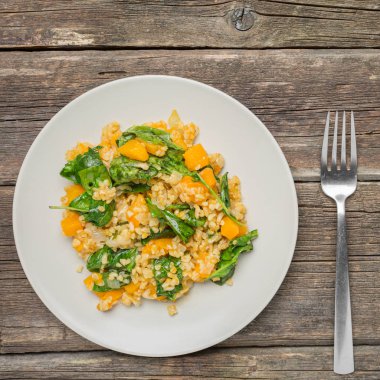 Bulgur sebze: balkabağı, soğan ve ahşap arka plan - sağlıklı ev yapımı organik vegan vejetaryen diyet yiyecek ıspanak