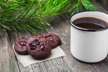 Beyaz emaye bir fincan kahve ile hommede ahşap arka plan üzerinde çikolata kurabiye fırından yeni çıkmış. Kış tatil kavramı