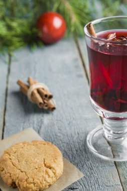 Tanımlama bilgileri ve çam dalları ve ahşap arka plan üzerinde kırmızı önemsiz şey ile tarçın dekore demet ile Noel Mulled şarap