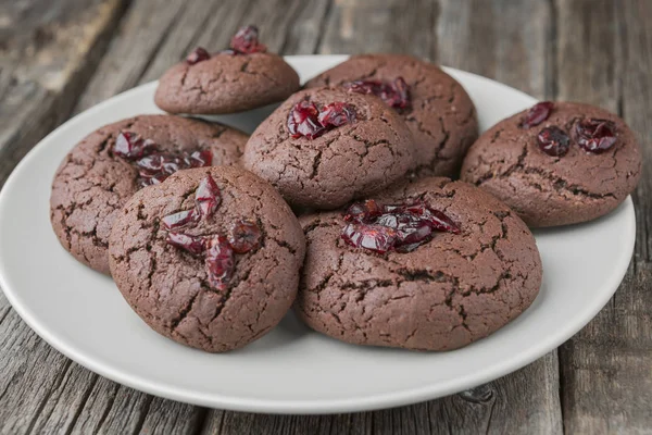 Homemade christmas and new year chocolate cookies with cranberry on wooden table background.