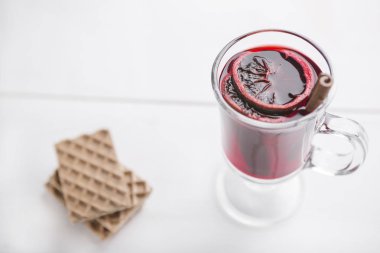 Beyaz ahşap arka planda Noel içeceği ve waffle. Baharatlı geleneksel mulled şarap. Noel, kış, yeni yıl konsepti.