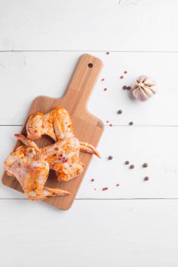 Kesme tahtası üzerinde çiğ tavuk kanadı