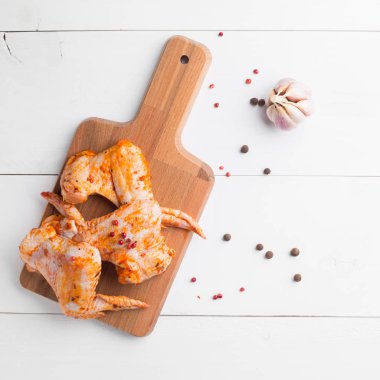 Kesme tahtası üzerinde çiğ tavuk kanadı