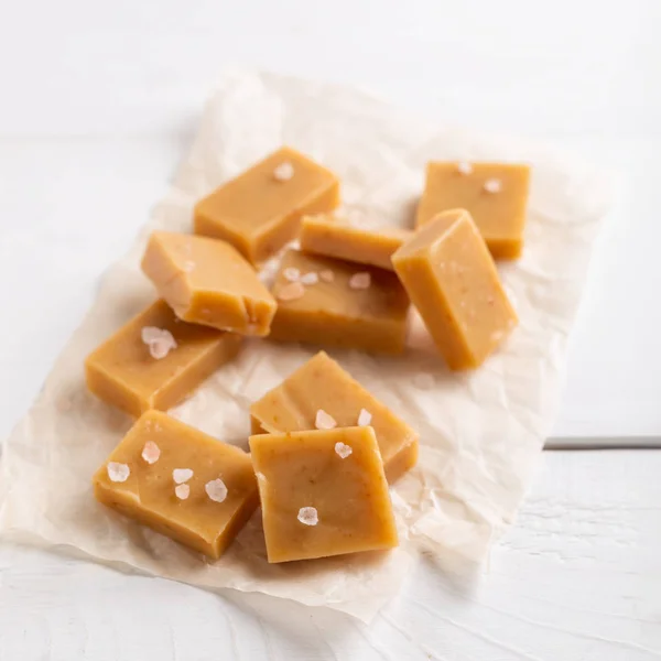 Salted caramel pieces and sea salt. Fresh caramel fudge candies — Stock Photo, Image