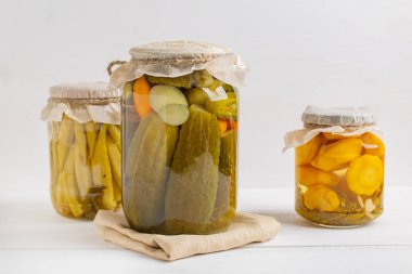 Salamura sebzeler kavanozlar: salatalık, domates, okra, rustik ahşap arka planda patlıcan.