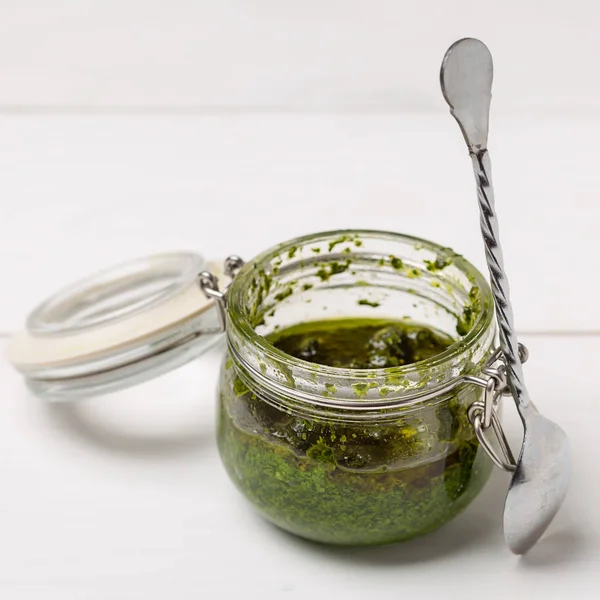 Jar with basil pesto sauce on table — Stock Photo, Image
