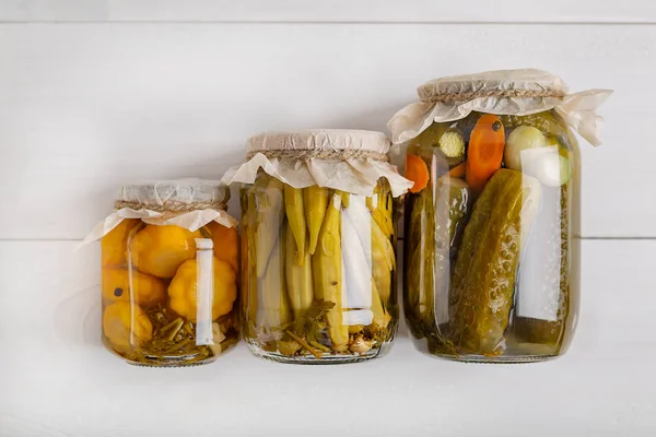 Salting various vegetables in glass jars for long-term storage. Preserves vegetables in glass jars. Top view. — Stock Photo, Image