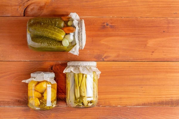 Salting various vegetables in glass jars for long-term storage. Preserves vegetables in glass jars. Top view. — Stock Photo, Image