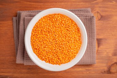 Ahşap arka plan üzerinde kırmızı mercimek kase