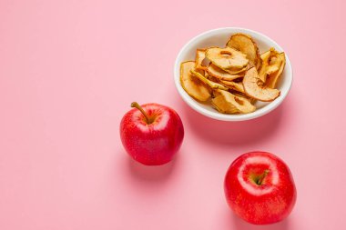 Seramik kase tablo taze kırmızı elma ile elma cips kurutulmuş