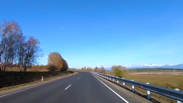 Autofahren auf einer herbstlichen Straße, Verkehr auf Spuren vor dem Hintergrund von Bergen, Wäldern — Stockvideo