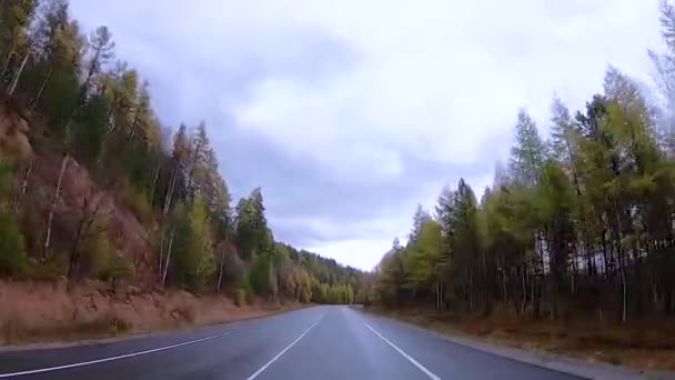 La conducción de un coche en una carretera de otoño, el tráfico de carriles en un fondo de montañas, bosques — Vídeos de Stock