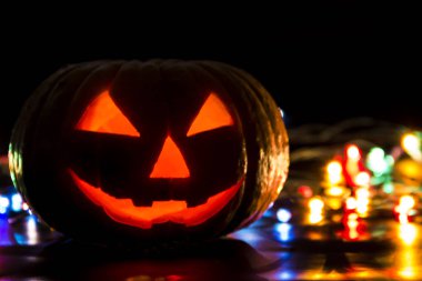 Gözleri, ağzı, burnu kesilmiş, parlak gözleri ve arka planı olan geleneksel uğursuz balkabağı kafası cehennem için bir boşluk.