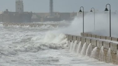 Ağır çekim görüntüleri büyük spreyler geçit üzerinde kale San Sebastian Cadiz İspanya yapma dev bir dalga gösteren. Dalgalar patika rulo olarak gösterildiği okyanus akıntılarının güçlü dalgalanmalara.