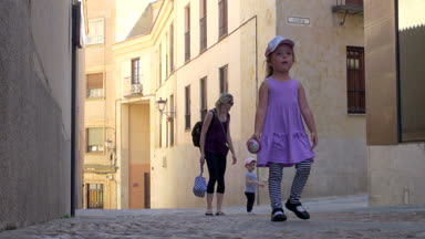 Küçük kız yürüyüş, topu elinde, Aile ile 