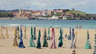 Renkli şemsiyeler Playa de San Lorenzo Beach Gijon kıyı fon kuma boyunca yürüyüş insanlar ile kapalı çeşitli yükleme görüntülerini kapat.