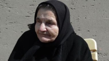 Elderly woman drinking coffee.
