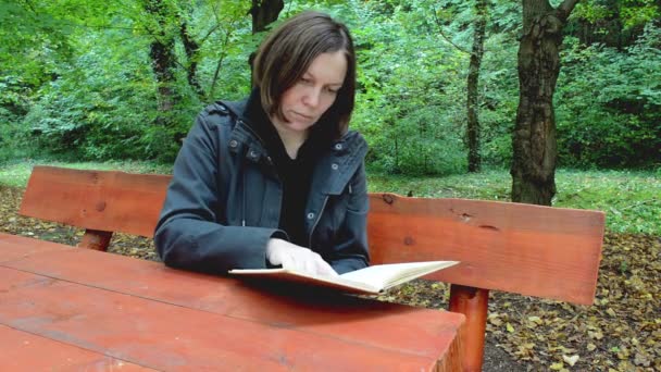 きれいな女性が公園で本を読んで — ストック動画