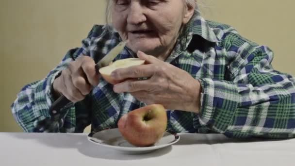 高齢者の女性がリンゴをスライス — ストック動画