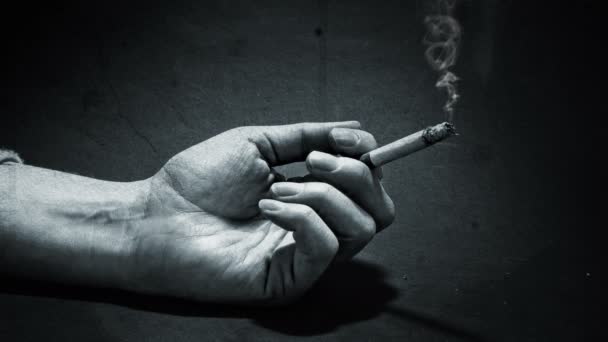 手与燃烧的香烟在一个粗野的背景 — 图库视频影像