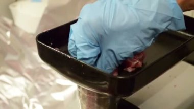 Elle kıyma makinesiyle kıyma yapmak. İnsan eti kıyma makinesine yükler.