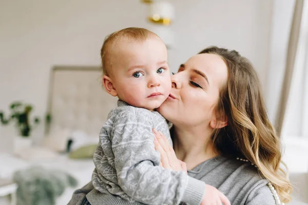 Hermosa joven madre besando a su lindo hijo — Foto de Stock