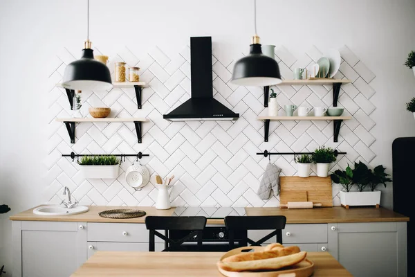 Ευρύχωρη, μοντέρνα σκανδιναβική κουζίνα με λευκά πλακάκια και μαύρες συσκευές. Φωτεινό δωμάτιο. Μοντέρνο εσωτερικό. — Φωτογραφία Αρχείου