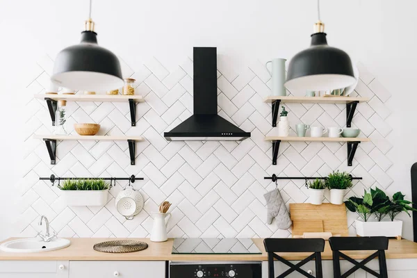 Ευρύχωρη, μοντέρνα σκανδιναβική κουζίνα με λευκά πλακάκια και μαύρες συσκευές. Φωτεινό δωμάτιο. Μοντέρνο εσωτερικό. — Φωτογραφία Αρχείου