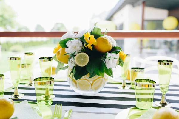 Ένα μπουκέτο λουλούδια με λεμόνια σε ένα γυάλινο βάζο σε ένα εορταστικό τραπέζι σε εσωτερικούς χώρους — Φωτογραφία Αρχείου